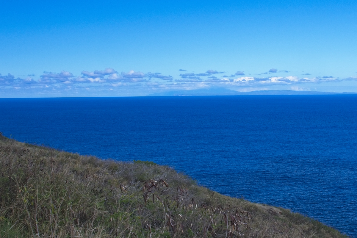 Faint outlines in the distance are the islands of Molokai and Maui behind